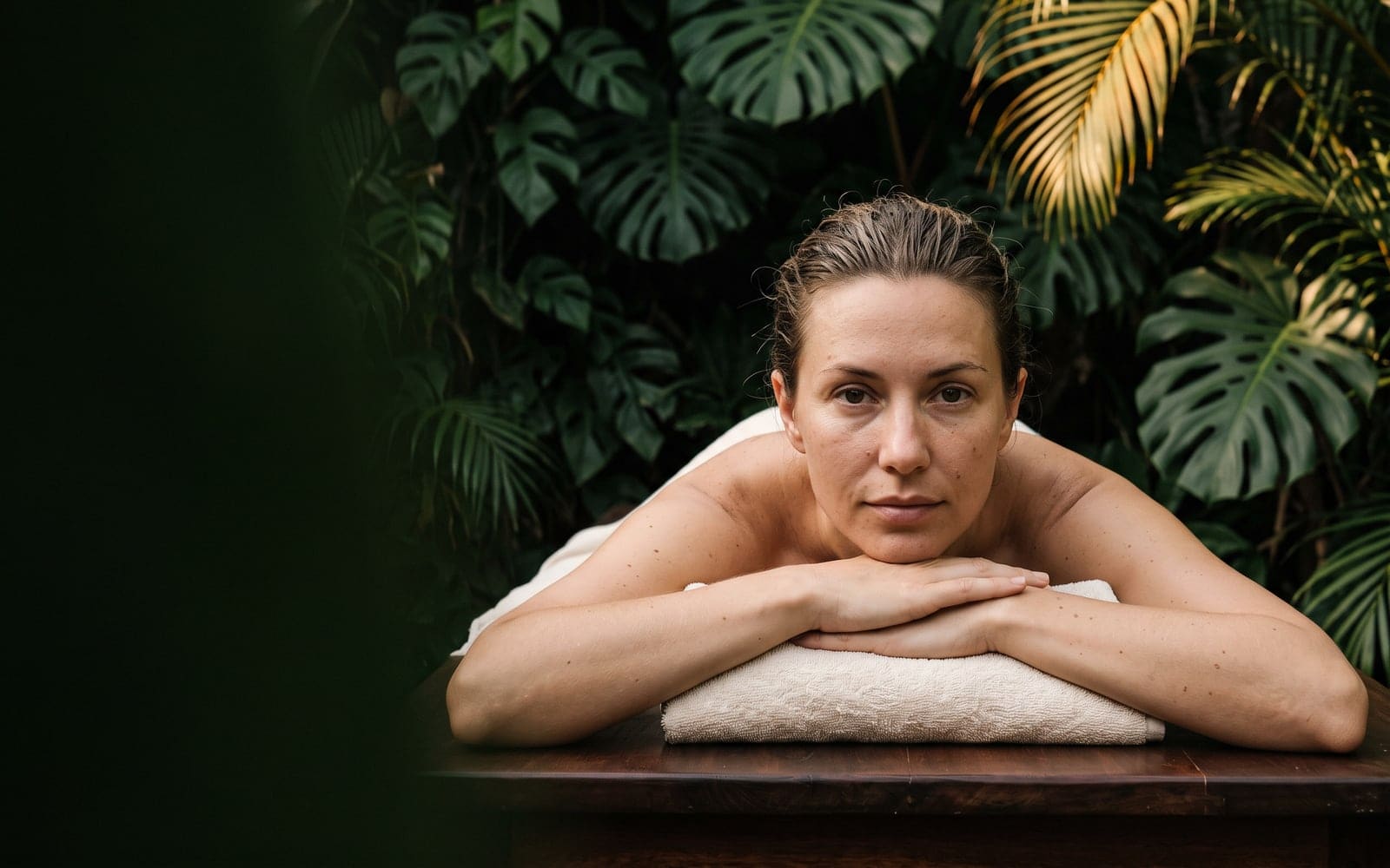 Paciente apoyada en la camilla, entre plantas tropicales